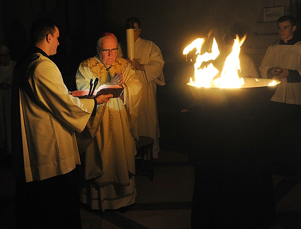 Bishop Richard J. Malone begins the Easter Vigil Mass at St. Joseph Cathedral in darkness with the blessing of the fire. (Dan Cappellazzo/Staff Photographer)
